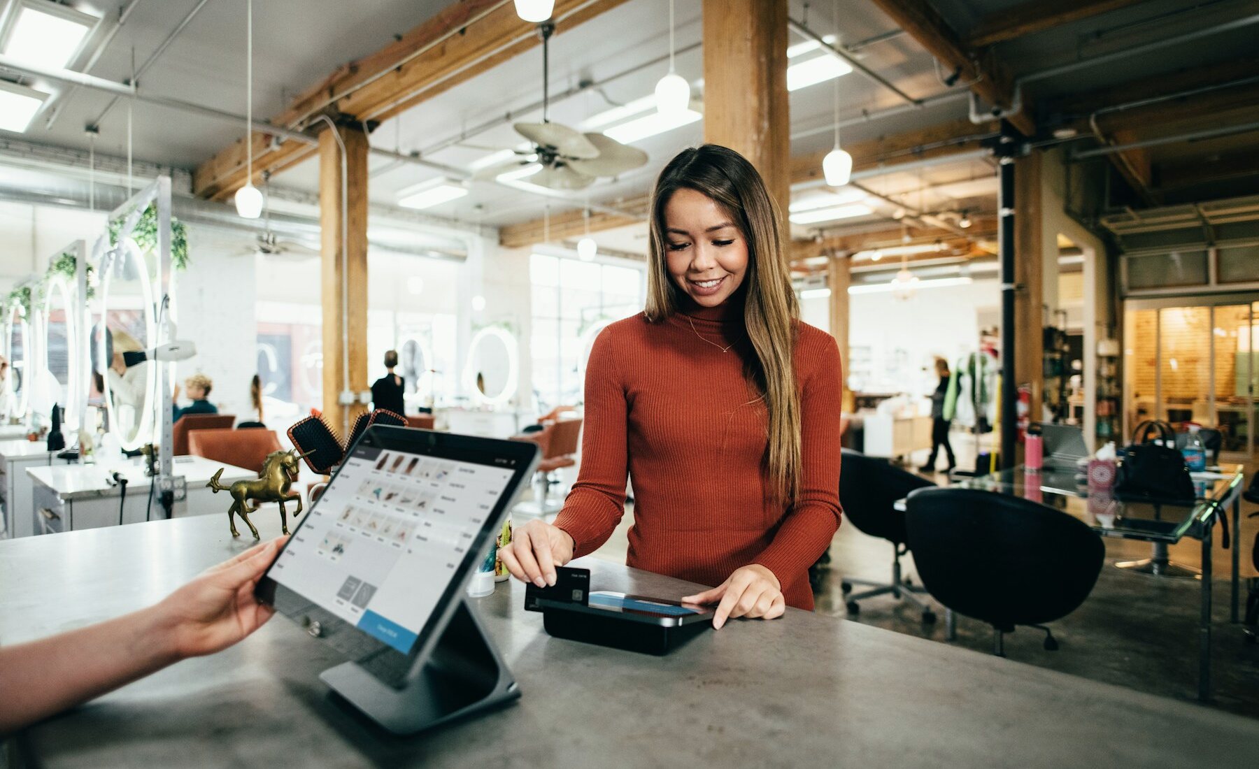 Woman presenting a payment card at a salon checkout