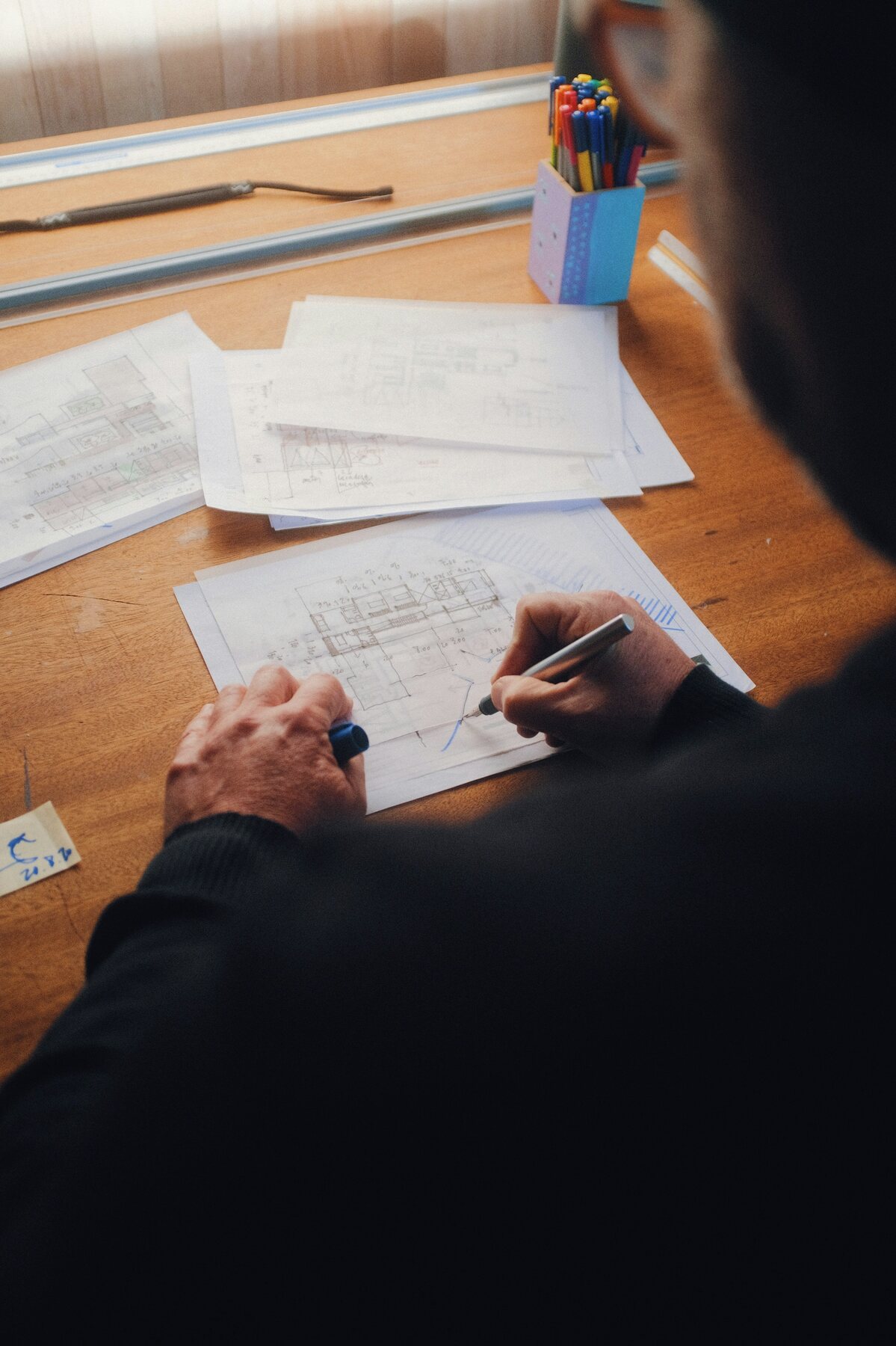 A professional reviewing architectural plans by hand